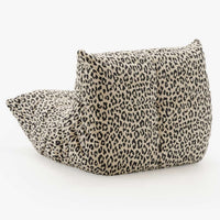 The Togo Fireside Chair, Tablu by Ligne Roset is a soft, low lounge chair featuring a leopard print fabric cover. Reminiscent of the iconic Togo design, it boasts a plush, tufted appearance and sits directly on the floor without visible legs or frame, embodying the essence of relaxed modular seating.