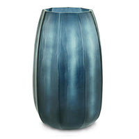 The Koonam Vase by Guaxs in Ocean Blue/Indigo features a tall, translucent glass design with vertical ridges and a slightly tapered, rounded shape, displayed against a white background.