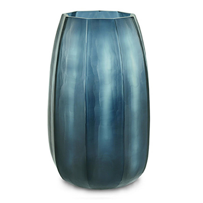 The Koonam Vase by Guaxs in Ocean Blue/Indigo features a tall, translucent glass design with vertical ridges and a slightly tapered, rounded shape, displayed against a white background.